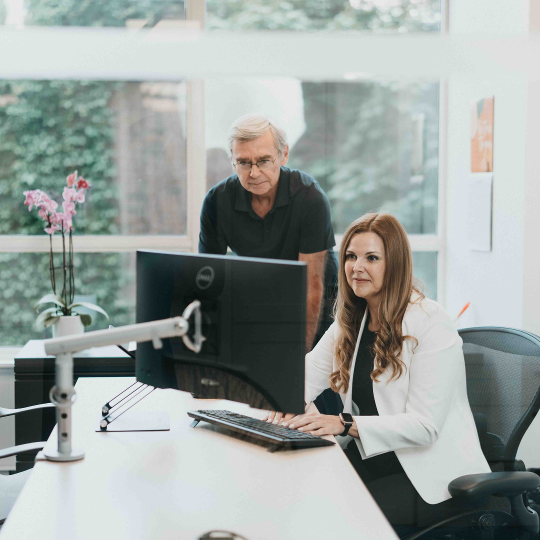Carson Dunlop CEO Karen Yolevski and President Alan Carson looking at desktop computer
