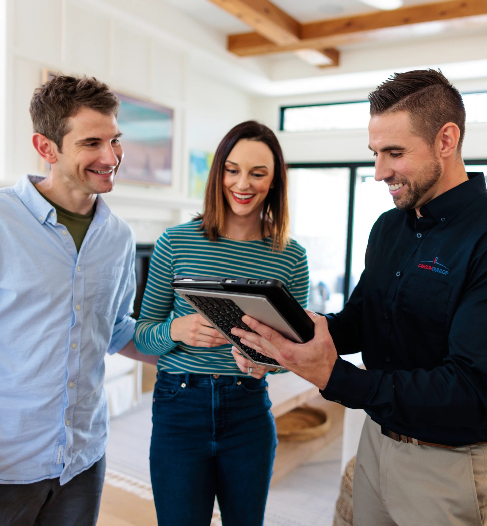 Inspector and homeowners sitting down and reviewing inspection results on tablet